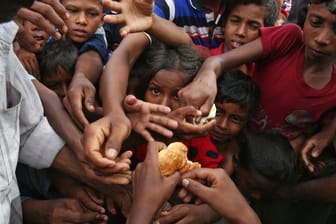 Flüchtlingskinder, der muslimischen Minderheit der Rohingyas, greifen in einem Flüchtlingslager in Bangladesch nach Etwas zu essen.