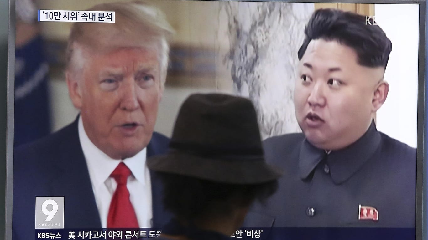 Ein Mann blickt in einer Bahnstation in Seoul auf einen Bildschirm, auf dem von einem Nachrichtensender Bilder von Nordkoreas Staatschef Kim Jong Un (r) und US-Präsident Donald Trump gezeigt werden.