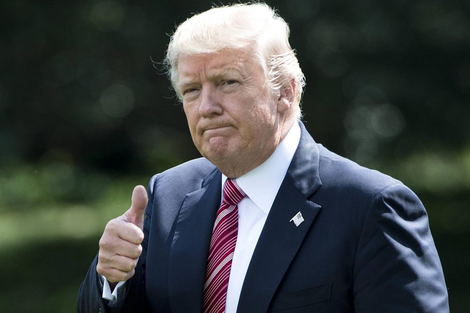 Donald Trump vor dem Weißen Haus zeigt den Daumen hoch.
