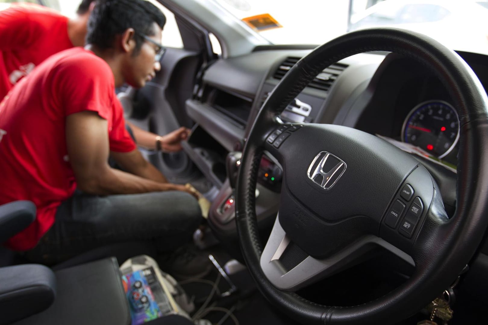 Ein Techniker tauscht einen fehlerhaften Airbag in einem Auto von Honda aus.