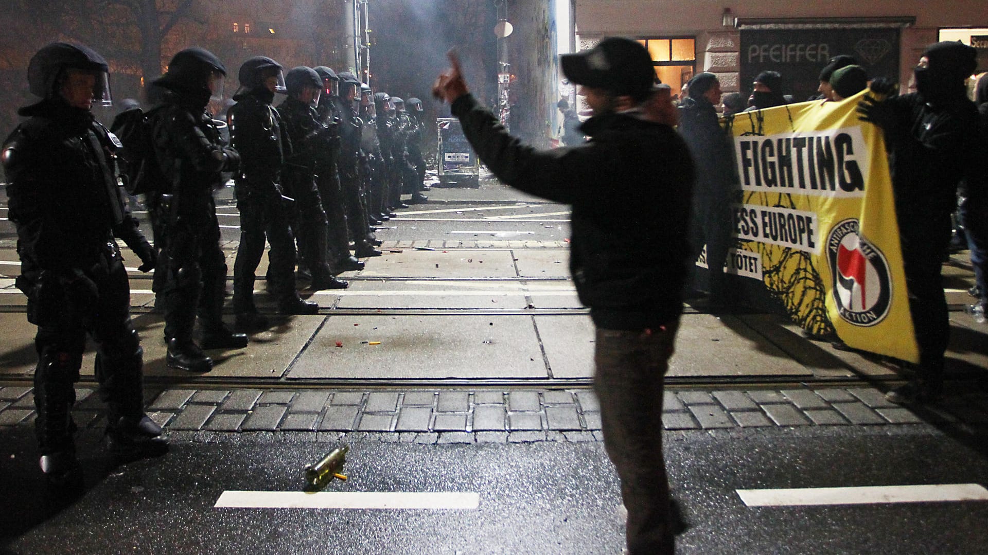 Polizisten stoppen in Leipzig auf einer Straße im Stadtteil Connewitz linke Spontandemonstranten.