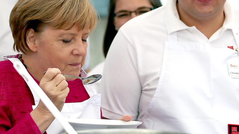 Bundeskanzlerin Angela Merkel (CDU) probiert während eines Besuchs bei den Johannitern in der Feldküche Eintopf. Merkel mag selbstgekochte Kartoffelsuppe.