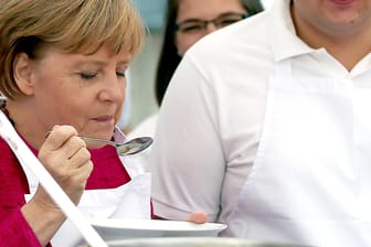 Bundeskanzlerin Angela Merkel (CDU) probiert während eines Besuchs bei den Johannitern in der Feldküche Eintopf. Merkel mag selbstgekochte Kartoffelsuppe.