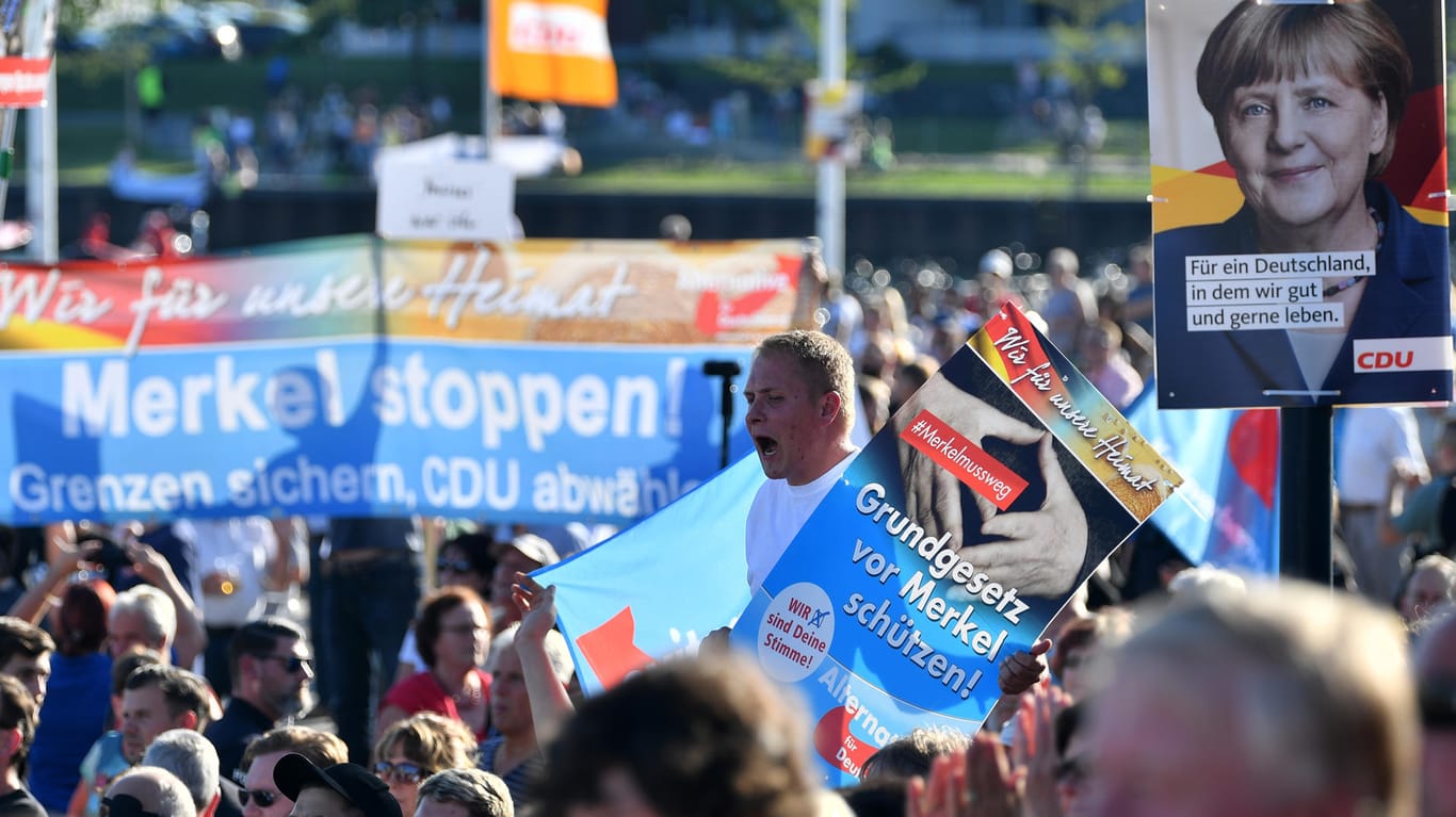 Mitglieder und Sympathisanten der AfD protestieren während eines Wahlkampfauftritts von Bundeskanzlerin Angela Merkel in Bitterfeld-Wolfen (Sachsen-Anhalt).
