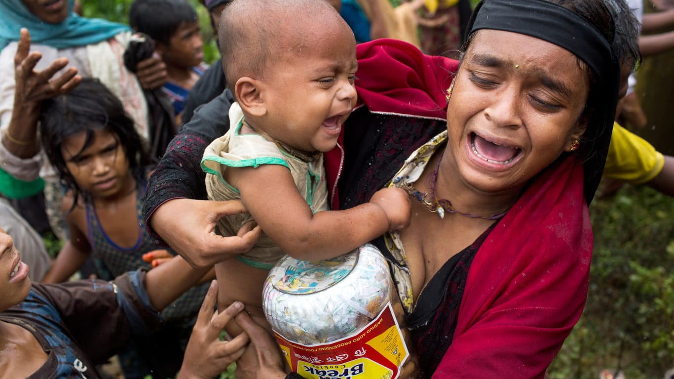 Eine Angehörige der muslimischen Minderheit der Rohingyas hält an einer Lebensmittelverteilungsstelle in einem Flüchtlingslager in Kutupalong (Bangladesch) weinend ein Kleinkind, nachdem es dort eine Schlägerei gab.