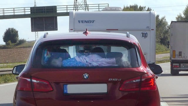 Das Polizeifoto zeigt das völlig ungesicherte Kind, das auf der Hutablage schläft. Das Polizeifoto zeigt das völlig ungesicherte Kind, das auf der Hutablage schläft.