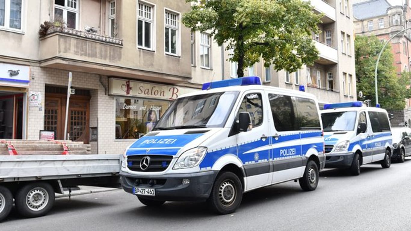 Polizeiwagen stehen während einer Razzia gegen Scheinehen vor einem Haus in Berlin.