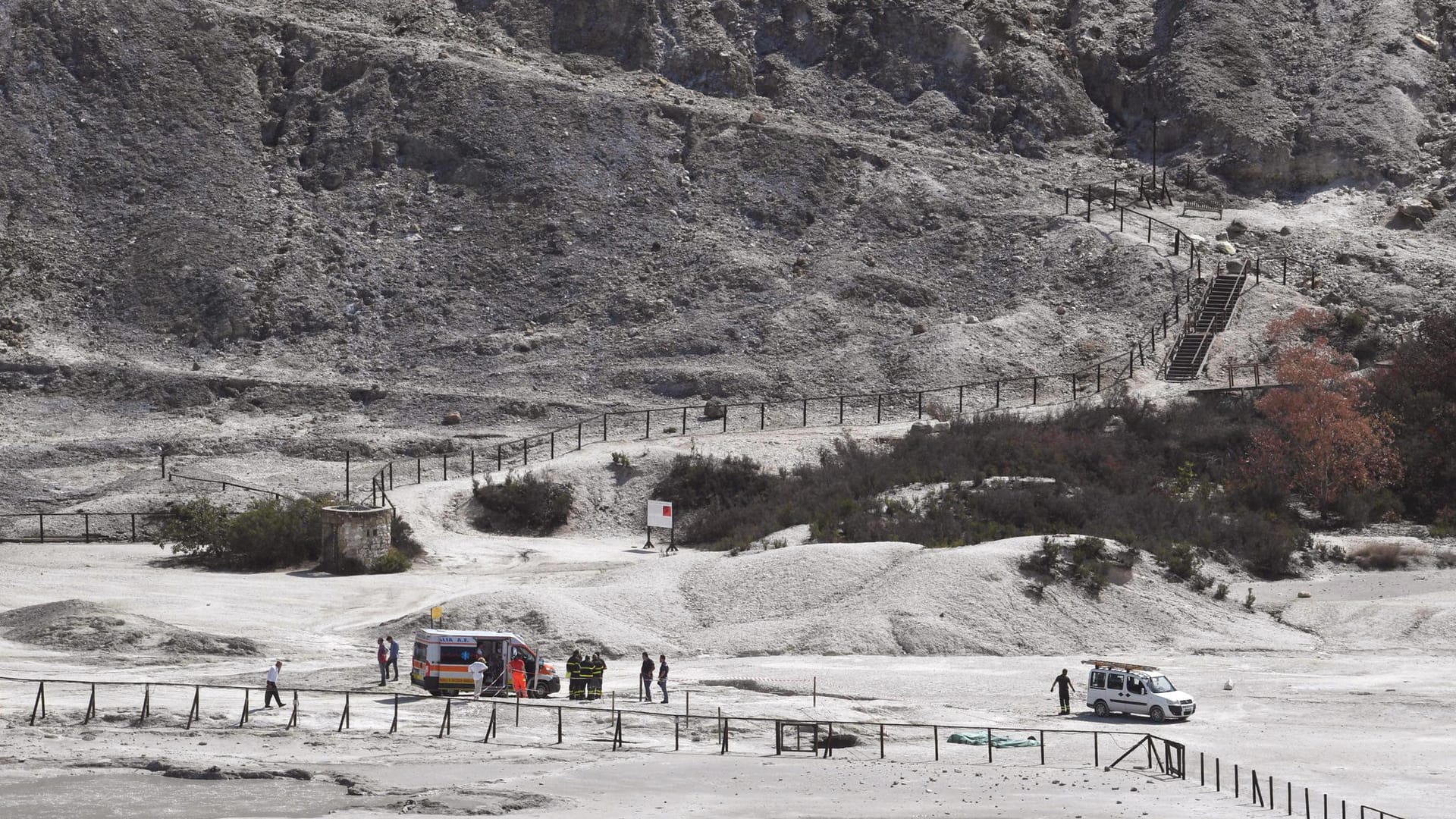 Feuerwehrmänner und Polizisten stehen auf einem Vulkanfeld in Pozzuoli in der Nähe von Neapel. Ein elfjähriger Junge und dessen Eltern sind in einem Krater des Vulkanfelds ums Leben gekommen. Feuerwehrmänner und Polizisten stehen auf einem Vulkanfeld in Pozzuoli in der Nähe von Neapel. Ein elfjähriger Junge und dessen Eltern sind in einem Krater des Vulkanfelds ums Leben gekommen.