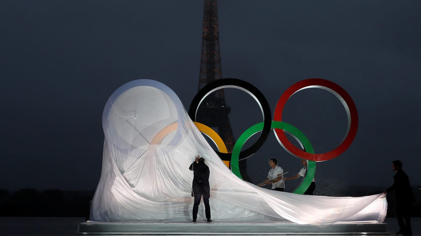 Der Eiffelturm im Hintergrund, die olympischen Ringe im Vordergrund.