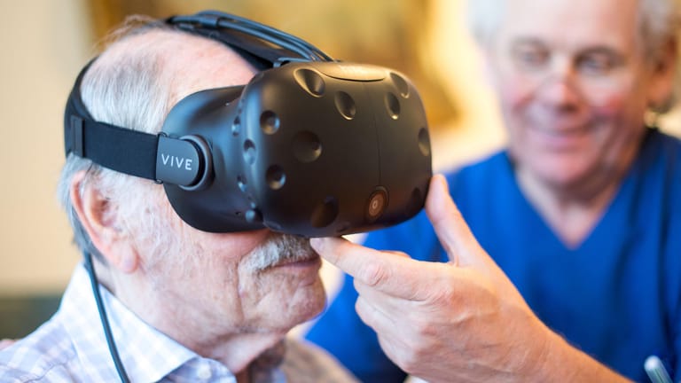 Friedhelm Caspers, Chefarzt Geriatrie, setzt einem Demenzpatienten eine Virtual-Reality-Brille auf.