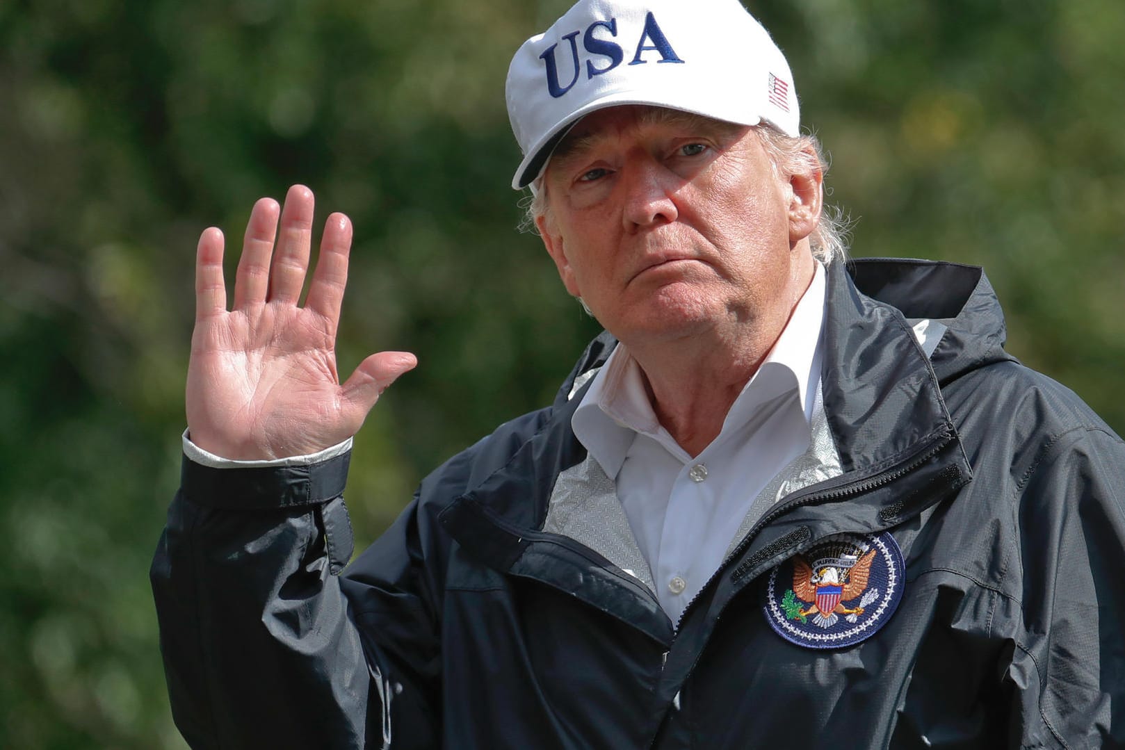 Donald Trump winkt vor dem Weißen Haus den Fotografen zu.