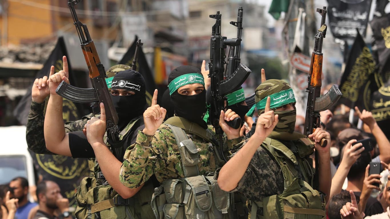 Kämpfer des militärischen Hamas-Flügels zeigen bei einer Beerdigung in Rafah ihre Waffen.