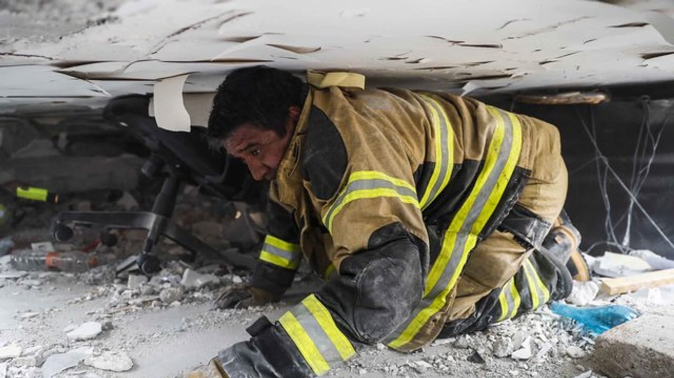 Verzweifelte Suche: Ein Feuerwehrmann versucht, in einem zerstörten Gebäude in Mexiko-Stadt Überlebende des schweren Erdbebens aufzuspüren.