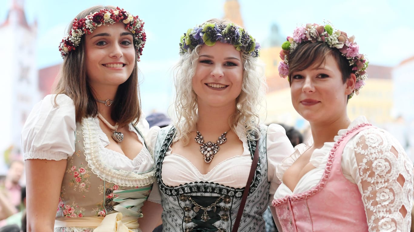 Die Besucherinnen Laura, Franziska und Lena (von links nach rechts) tragen Blumenkränze im Haar und haben sich für ein etwas freizügigeres Dekolleté entschieden.