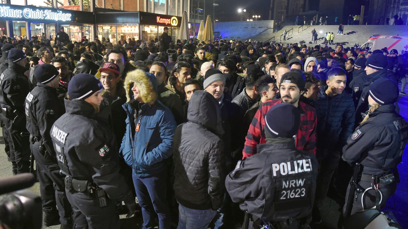 Polizisten umringen am 31.12.2016 vor dem Hauptbahnhof in Köln eine Gruppe von Männern.