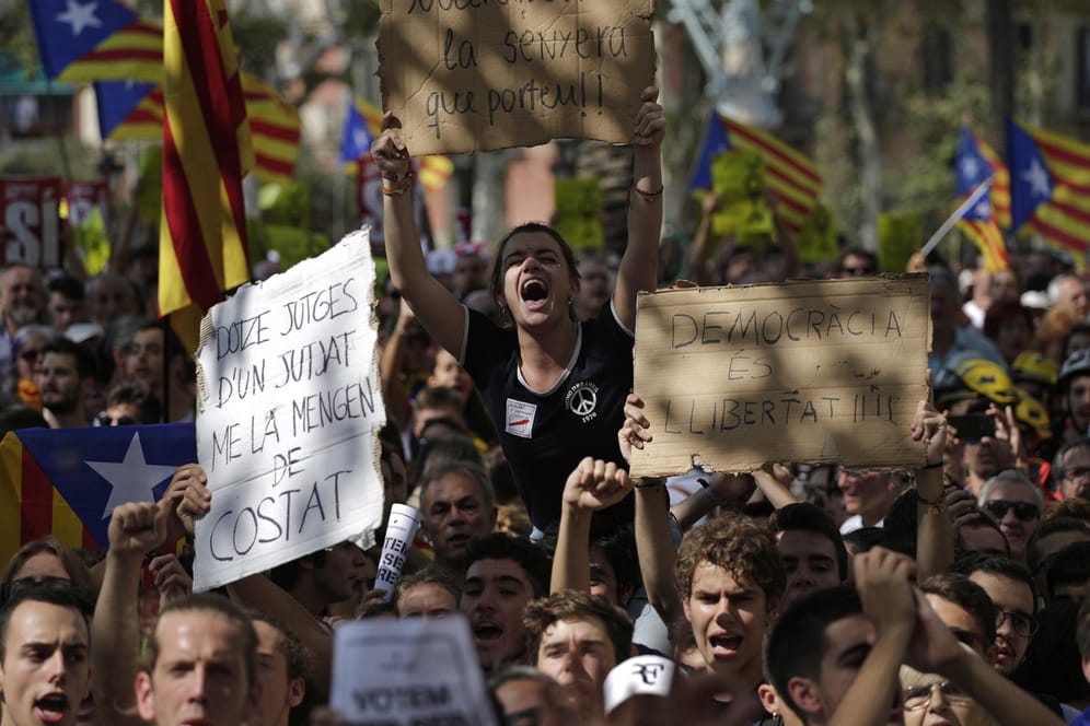 Demonstranten protestieren in Barcelona gegen die Razzien der spanischen Polizei.