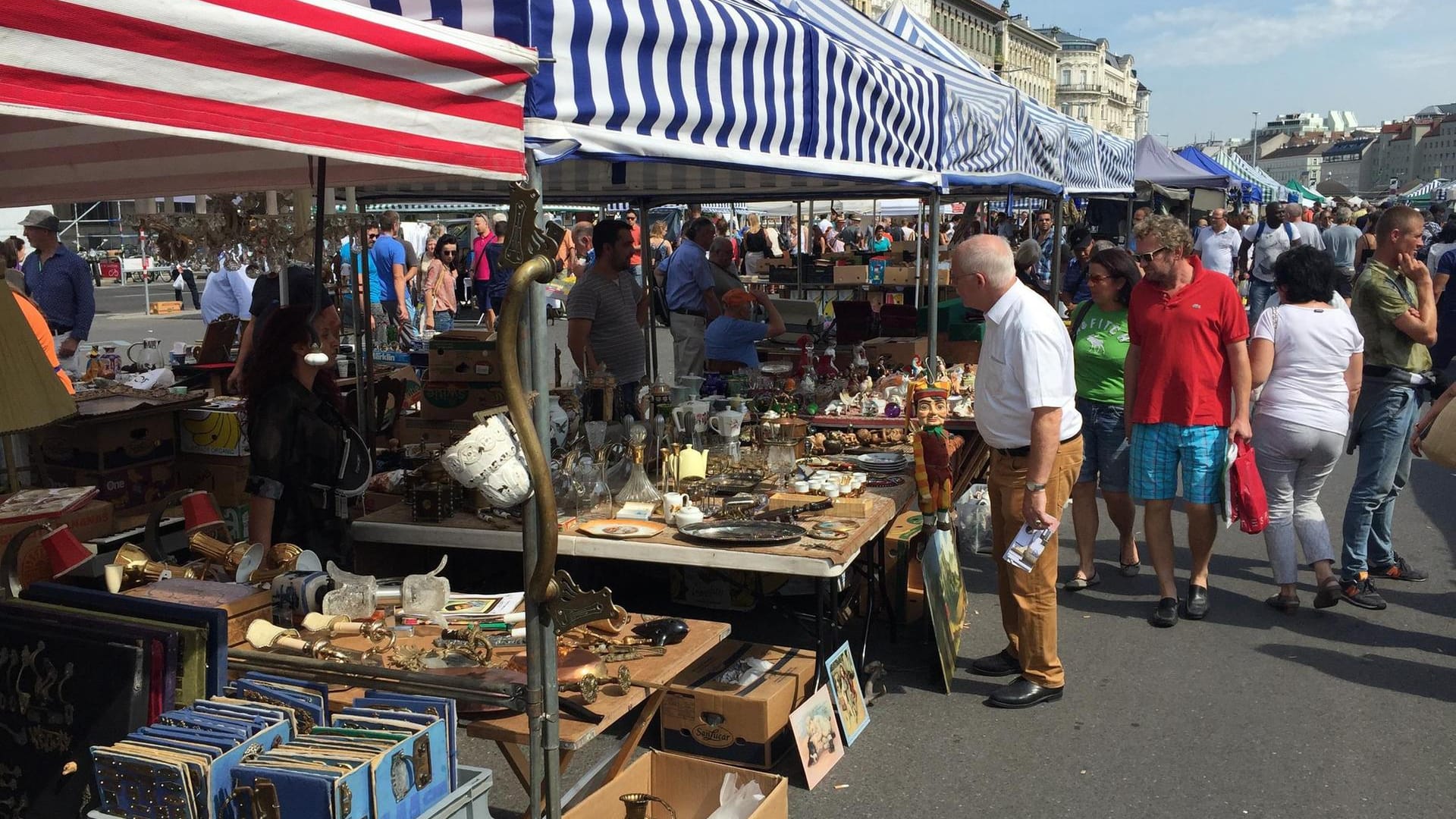 Wien – Neben den vielen Verkaufsständen auf dem Flohmarkt beim Naschmarkt lässt sich immer wieder ein Blick auf die wunderschönen, verzierten Gebäude erhaschen.