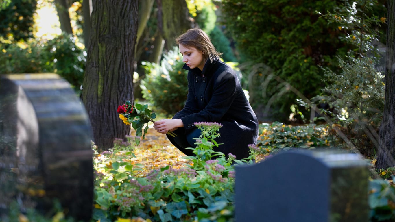 Frau auf einem Friedhof: Das Grab ist für Hinterbliebene ein wichtiger Ort zum Trauern.