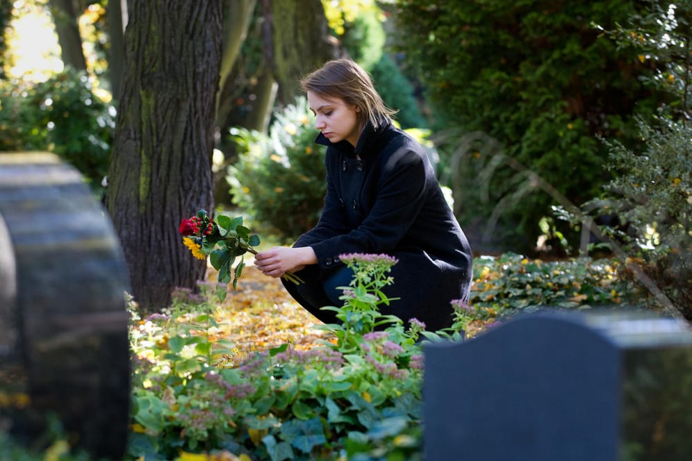 Frau auf einem Friedhof: Das Grab ist für Hinterbliebene ein wichtiger Ort zum Trauern.