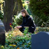 Frau auf einem Friedhof: Das Grab ist für Hinterbliebene ein wichtiger Ort zum Trauern.