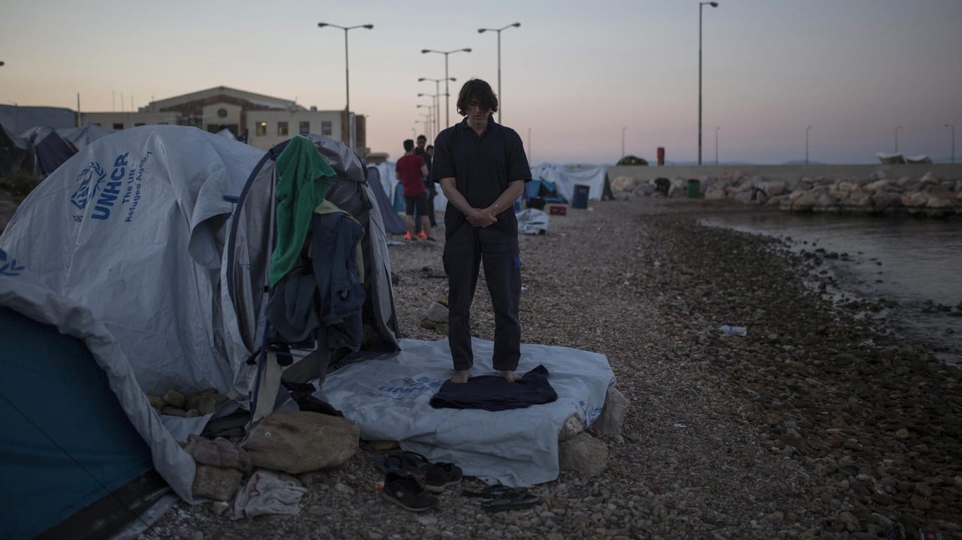 Ein Flüchtling aus Syrien betet am vor seinem Zelt am Flüchtlingslager Souda auf der Insel Chios, Griechenland