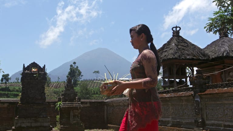 Ein Balinesin bringt in Karangasem (Indonesien) Opfergaben in einen Tempel der 10 Kilometer des Vulkans Mount Agung entfernt liegt. Auf der indonesischen Ferieninsel Bali wächst die Furcht vor einem gewaltigen Vulkanausbruch.