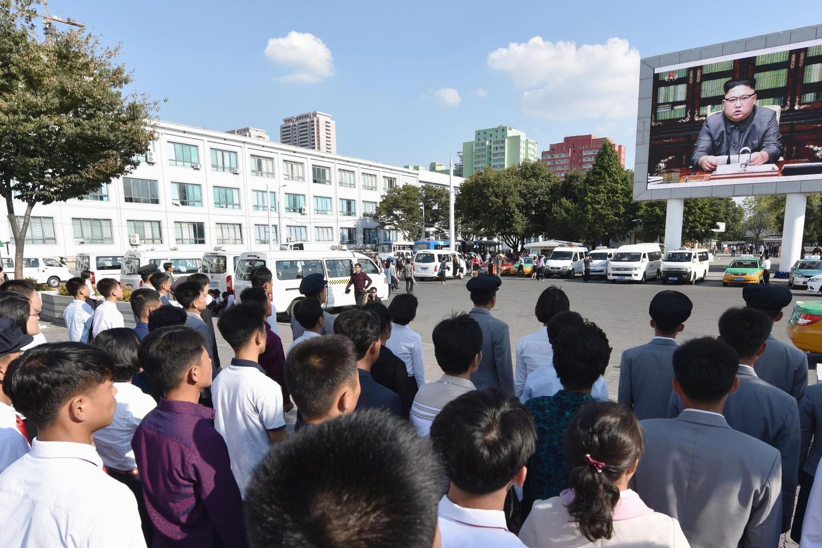 Passanten verfolgen eine Rede des nordkoreanischen Machthabers Kim Jong Un