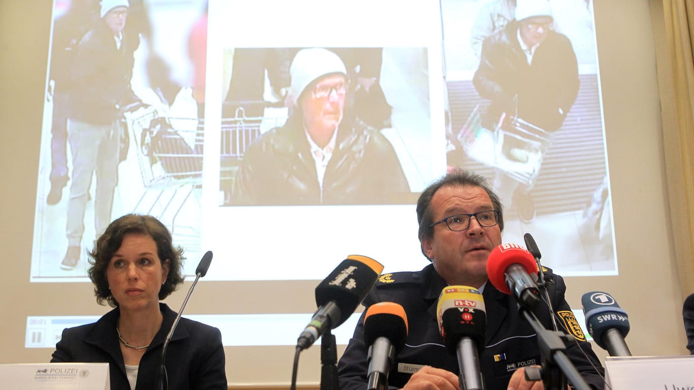Polizeivizepräsident Uwe Stürmer (r) vom Polizeipräsidium Konstanz und Ministerialrätin Petra Mock (l) bei einer Pressekonferenz. Im Hintergrund werden Fahndungsfotos des Tatverdächtigen gezeigt.