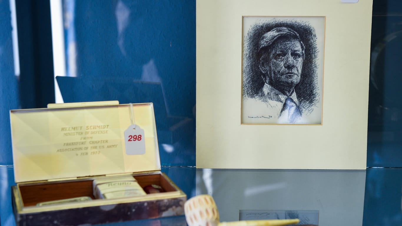 Eine Kohlezeichnung von Ex-Bundeskanzler Helmut Schmidt, eine Pfeife und ein Schmuckkästchen mit Zigaretten, Schnupftabak und Feuerzeug im Auktionshaus