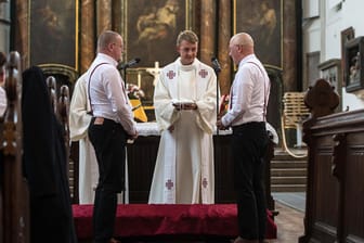 Sven Kretschmer (l) und Tim Schmidt-Kretschmer stehen beim Ringtausch bei der Trauung am 12.08.2016 in der Marienkirche in Berlin vor Pfarrer Eric Haußmann.