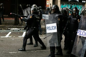 Ein spanischer Polizist zielt mit einem Gummigeschoss auf Demonstranten in Barcelona.