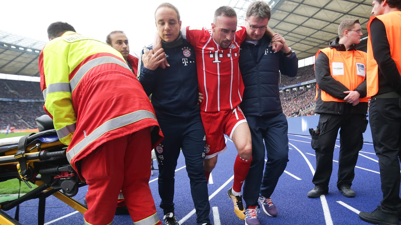 Ribéry wird von den Bayern-Betreuern vom Platz gebracht.