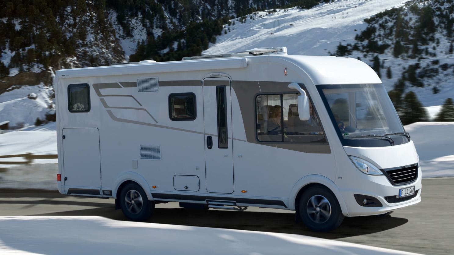 Wintercaravaning im Trend: Ein Caravan in Schneelandschaft Wintercaravaning im Trend: Ein Caravan in Schneelandschaft