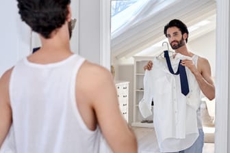 Vor dem Spiegel stellen sich viele Männer die Frage: Wie soll ich das Hemd tragen?