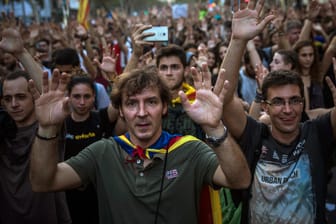 Demonstranten gehen in der katalanischen Regionalhauptstadt Barcelona durch die Innenstadt.