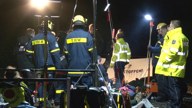 Polizisten und THW-Mitarbeiter stehen in Gronau an einem Protest von Atomkraftgegnern. Bei Gronau im Münsterland haben Atomkraftgegner über elf Stunden lang eine Bahnstrecke blockiert.