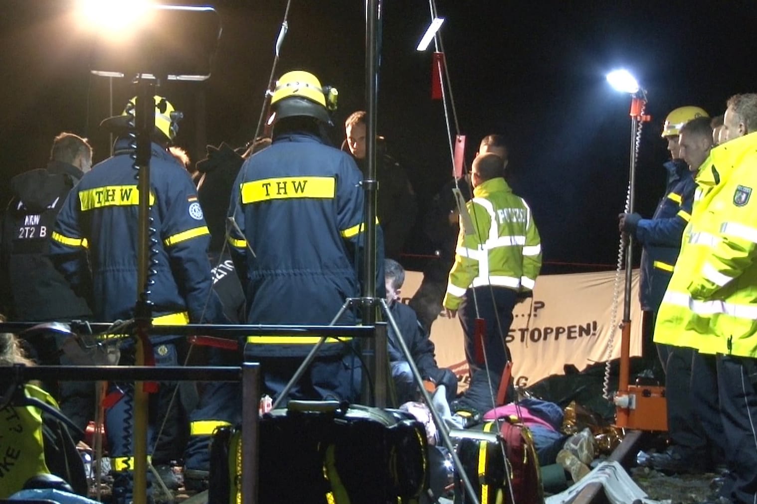 Polizisten und THW-Mitarbeiter stehen in Gronau an einem Protest von Atomkraftgegnern. Bei Gronau im Münsterland haben Atomkraftgegner über elf Stunden lang eine Bahnstrecke blockiert.