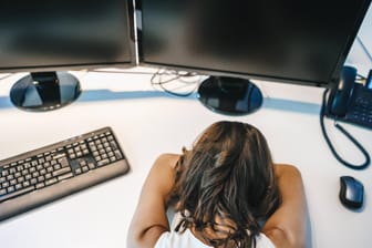 Überarbeitet: Frau schläft auf ihrem Bürotisch