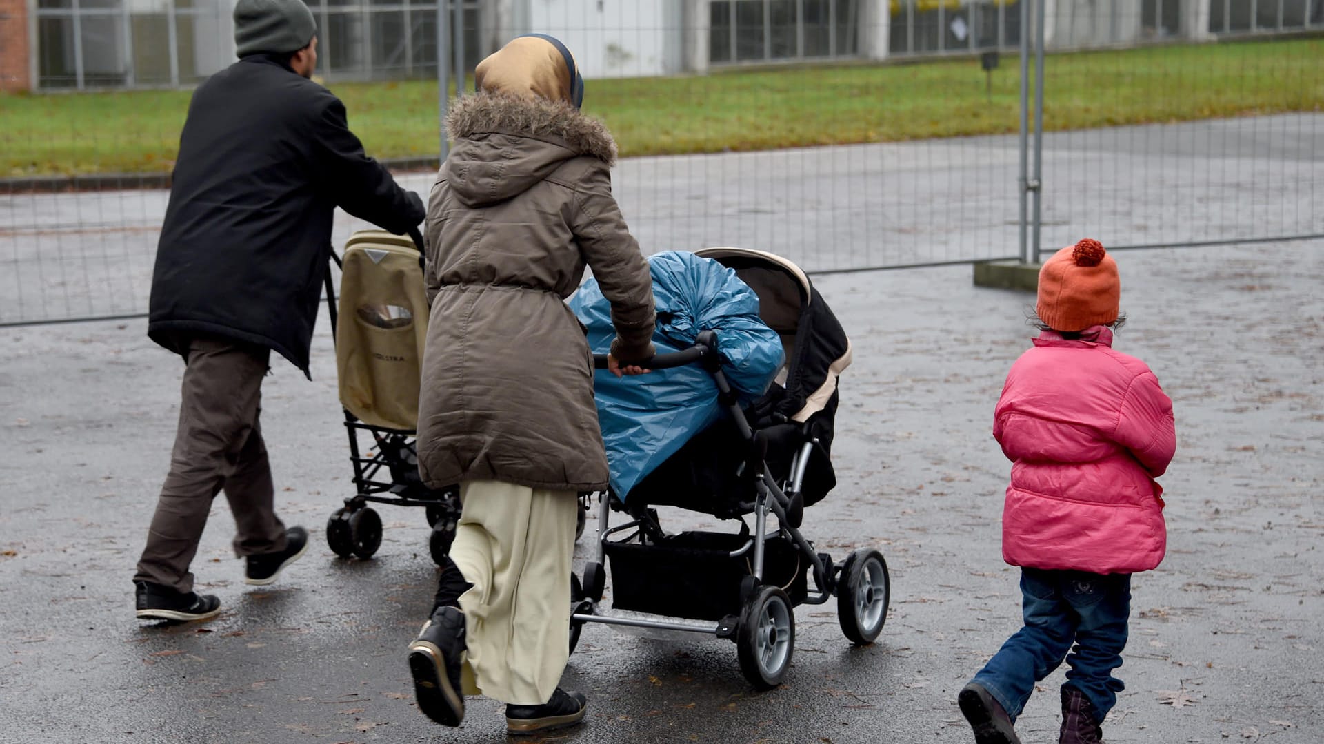 Flüchtlinge gehen über ein Gelände einer Erstaufnahmeeinrichtung in Deutschland. Nur ein sehr kleiner Teil syrischer Flüchtlinge, die nach Deutschland weiterreisen durften, wurde tatsächlich ins Land gelassen. Flüchtlinge gehen über ein Gelände einer Erstaufnahmeeinrichtung in Deutschland. Nur ein sehr kleiner Teil syrischer Flüchtlinge, die nach Deutschland weiterreisen durften, wurde tatsächlich ins Land gelassen.