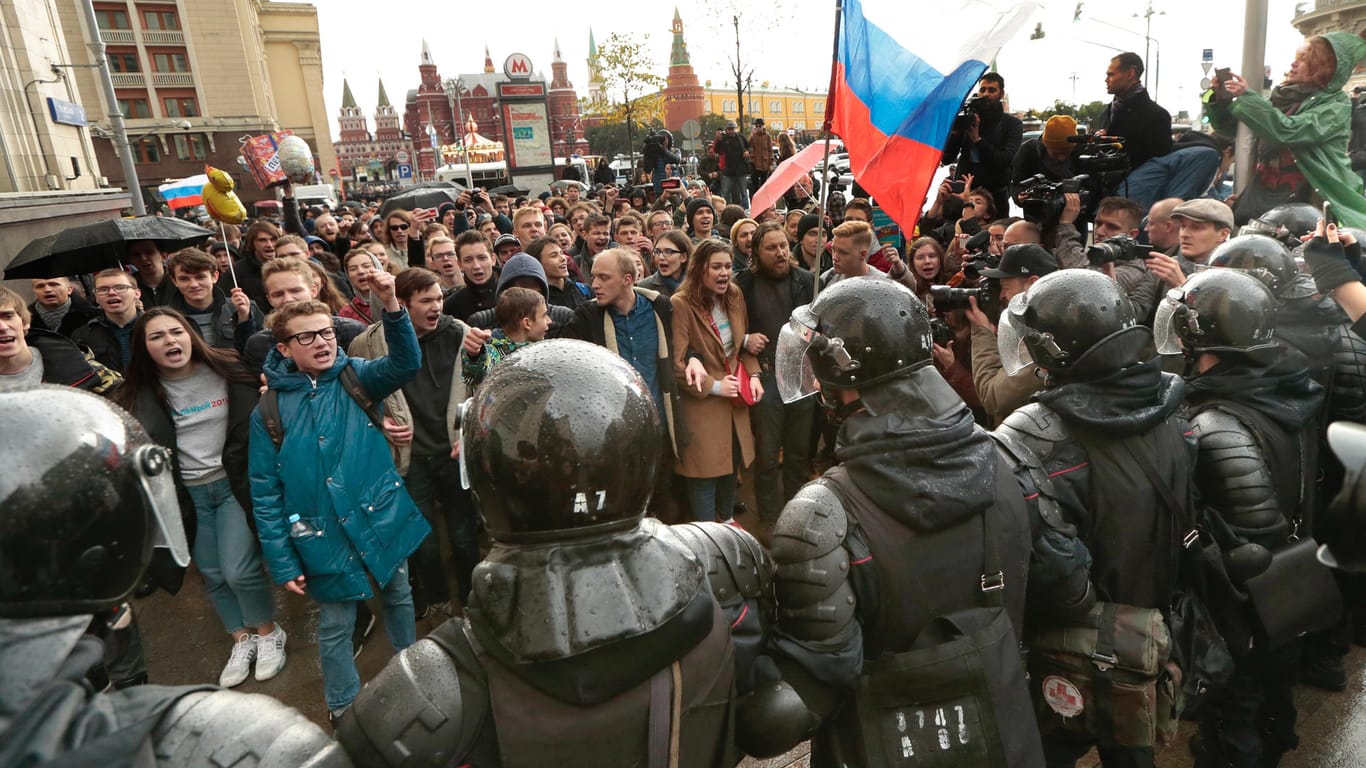Polizisten stellen sich in Moskau Demonstranten einer Großdemonstration zu Präsident Wladimir Putins 65. Geburtstag in den Weg. Der Kreml-Kritiker Alexej Nawalny hat landesweit in rund 80 Städten zu Protesten gegen die Staatsspitze und für freie und faire Wahlen aufgerufen.