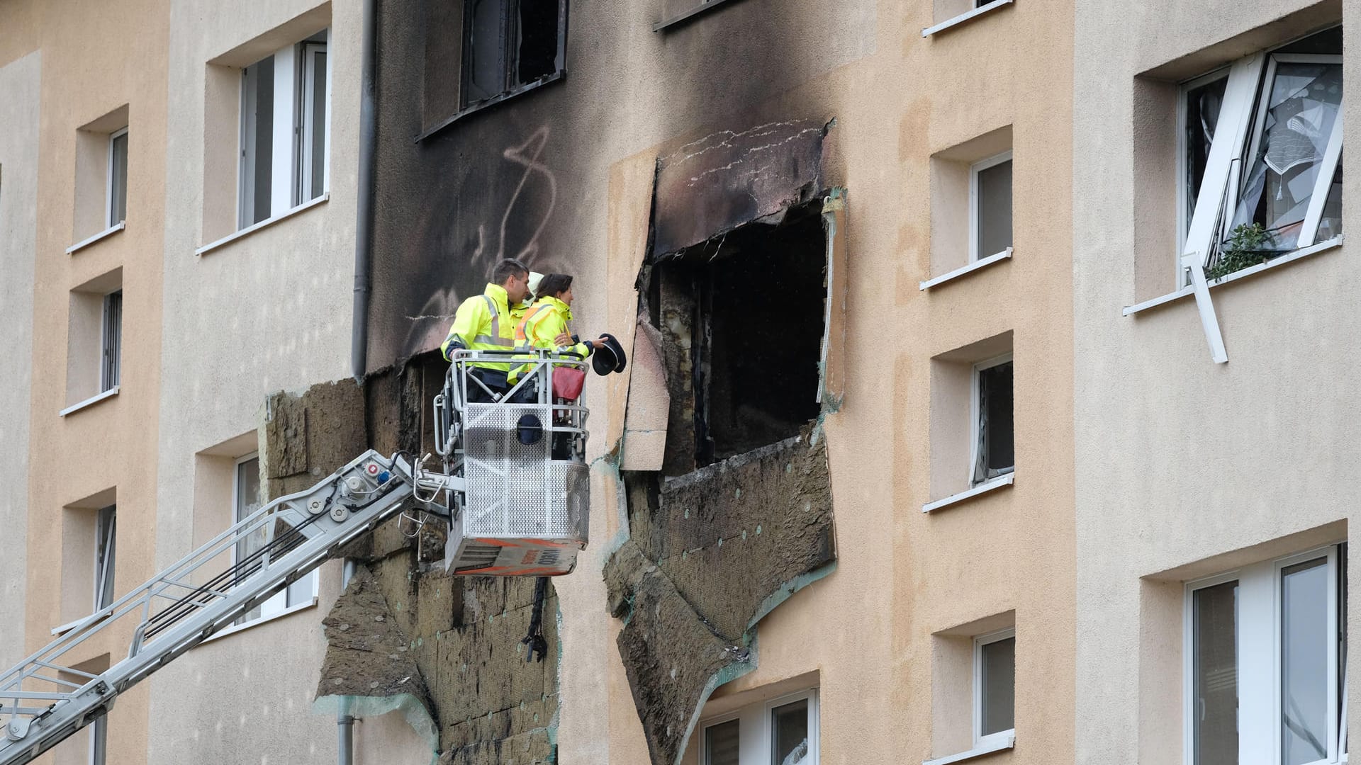 Polizisten begutachten von der Drehleiter aus das Wohnhaus, an dem das Feuer wütete.