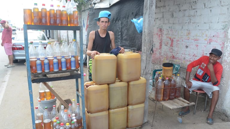 Der aus Venezuela geflüchtete Ider Villalobos steht in der Grenzstadt Maicao vor Kanistern mit geschmuggeltem Benzin, die er hier verkauft.