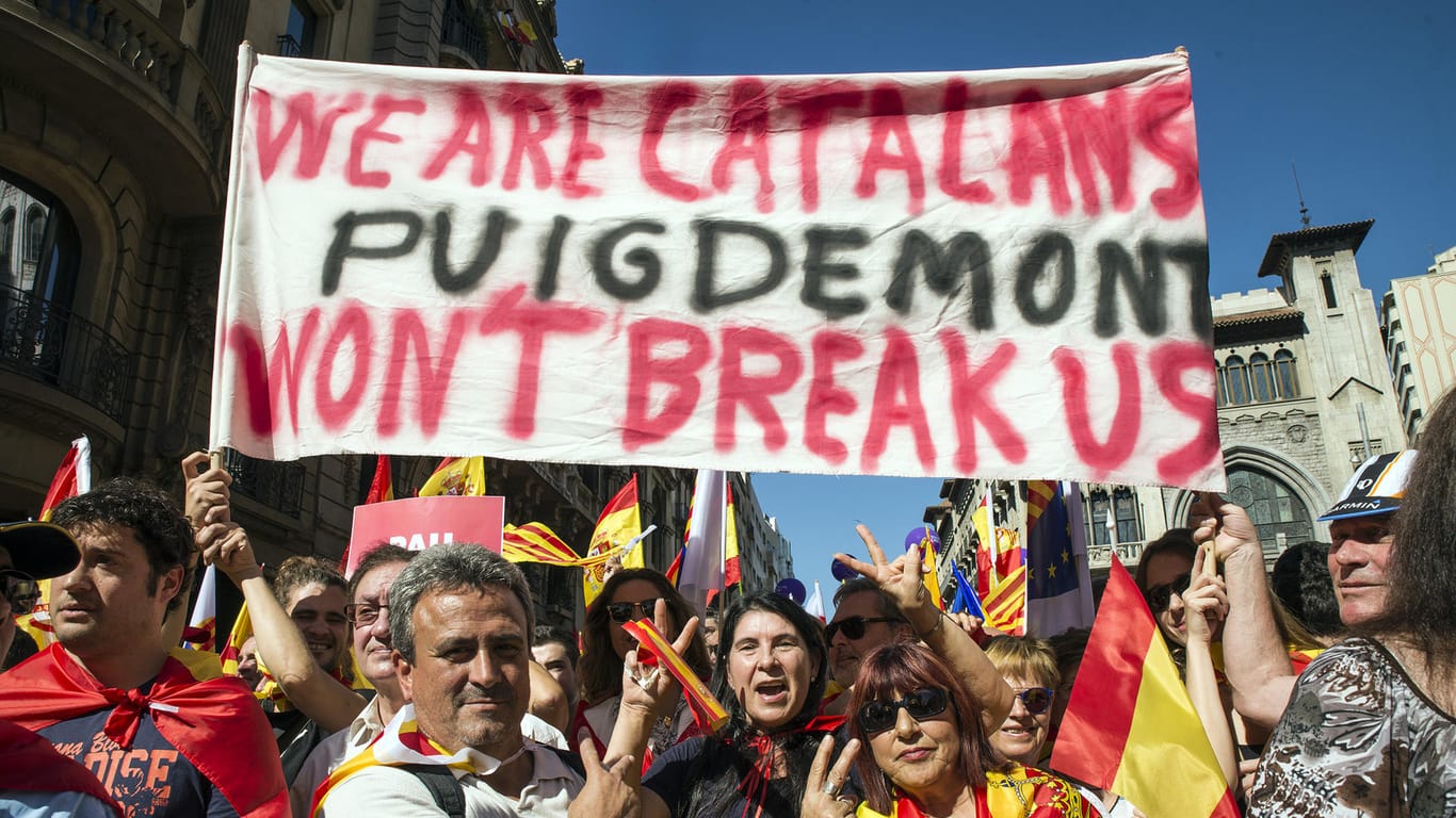 Demonstranten halten ein Schild mit der Aufschrift "Wir sind Katalanen. Puigdemont wird uns nicht zerbrechen" beim Protest in Barcelona.