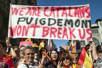 Demonstranten halten ein Schild mit der Aufschrift "Wir sind Katalanen. Puigdemont wird uns nicht zerbrechen" beim Protest in Barcelona.
