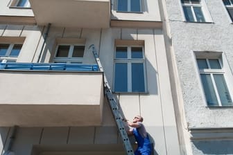 Mann lehnt Leiter an einen Balkon: Was macht der denn da, ist das ein Einbrecher? Verdächtige Beobachtungen wie diese sollten der Polizei unter 110 gemeldet werden.