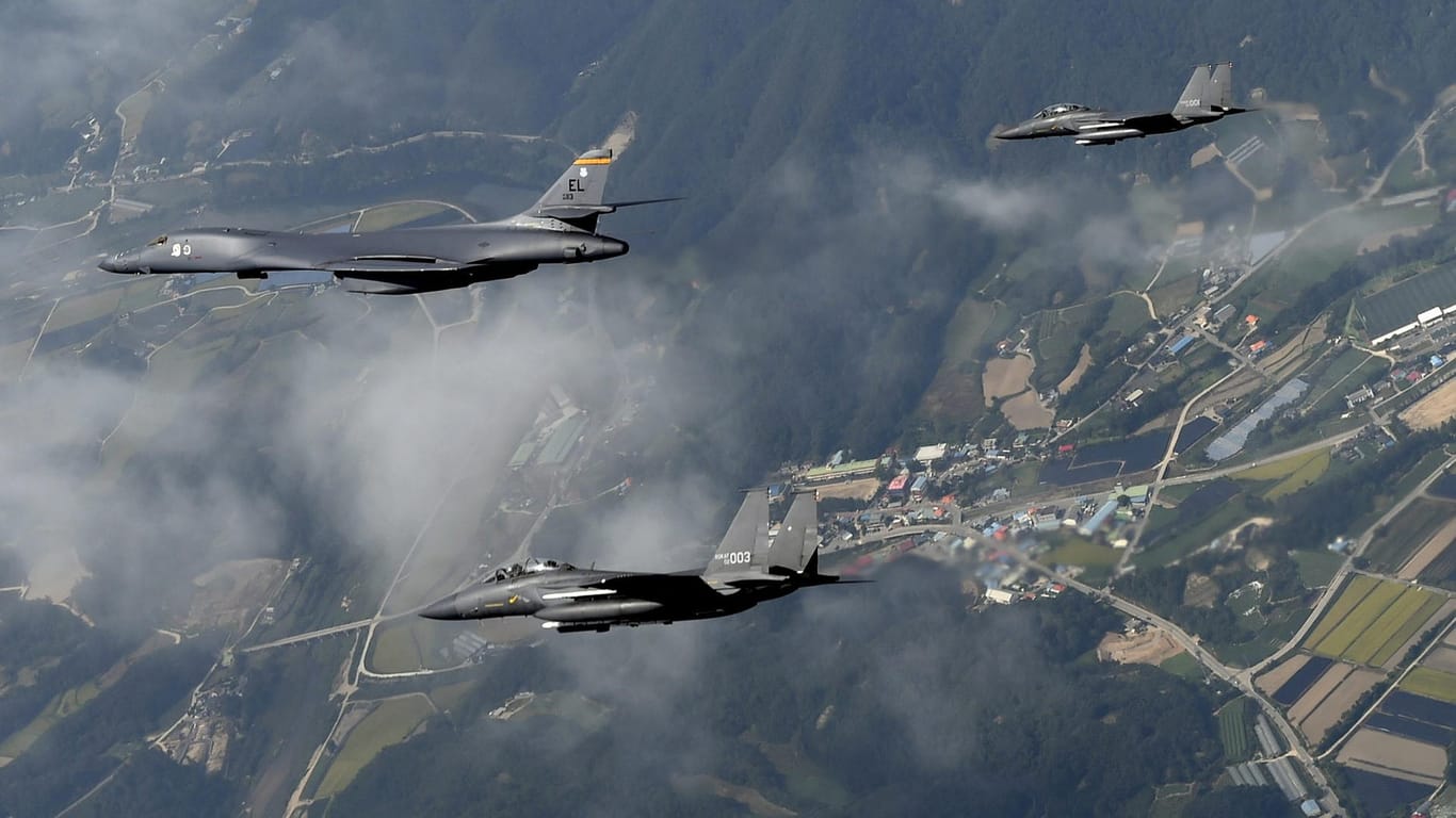 Drei südkoreanische F-15-Kampfflugzeuge bei einem Manöver mit einem B-1B-Bomber der USA.