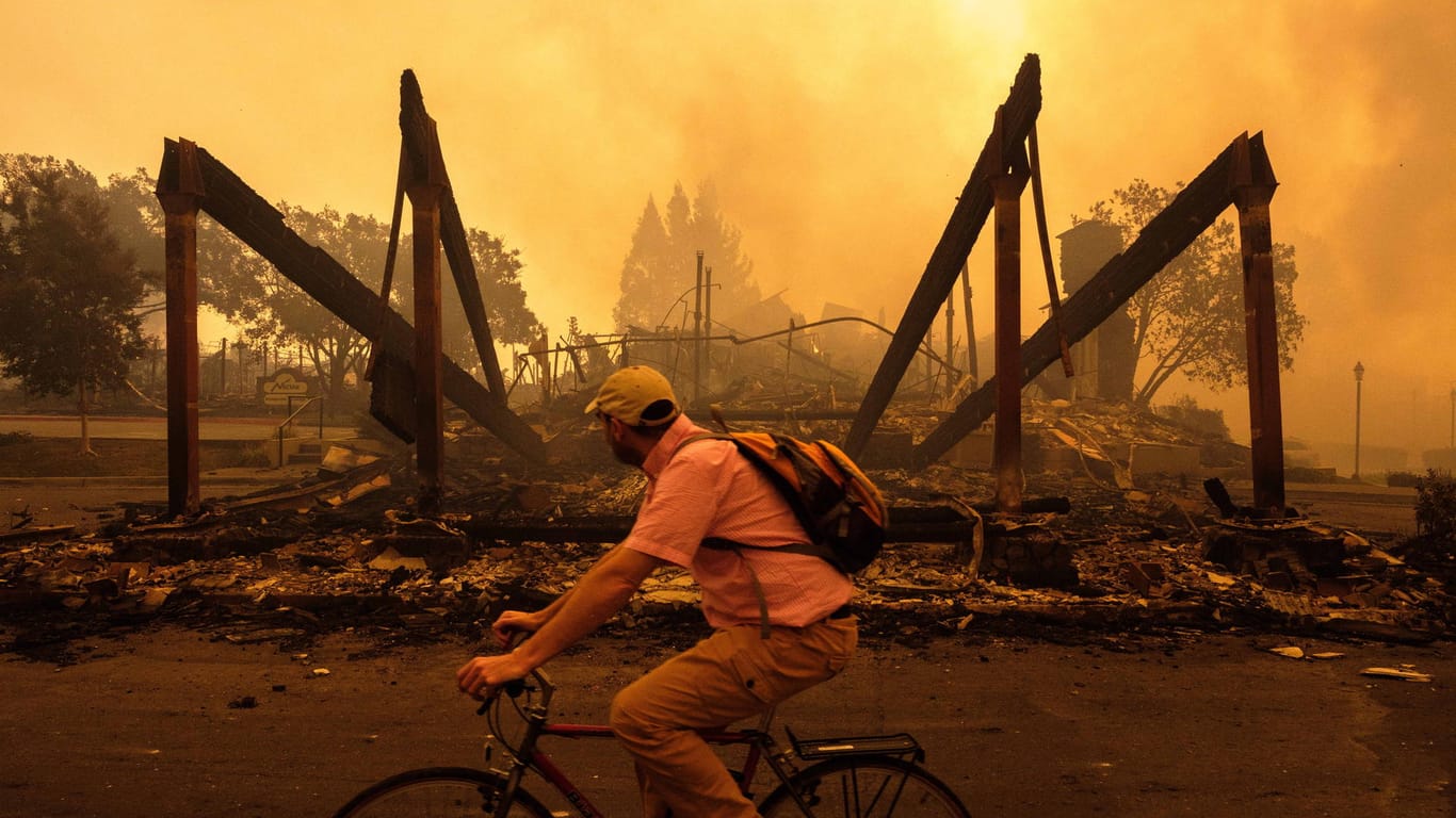 Ein Fahrradfahrer fährt in Santa Rosa in Kalifornien an den Überresten eines Hilton-Hotels vorbei. Die Zahl der Toten bei den verheerenden Wald- und Buschbränden im Norden Kaliforniens hat sich auf 17 erhöht.