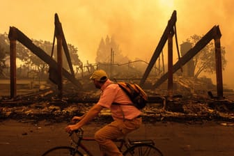 Ein Fahrradfahrer fährt in Santa Rosa in Kalifornien an den Überresten eines Hilton-Hotels vorbei. Die Zahl der Toten bei den verheerenden Wald- und Buschbränden im Norden Kaliforniens hat sich auf 17 erhöht.