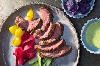 Rindersteak-Streifen mit eingelegtem Gemüse, Blaukartoffel-Chips und Petersilie-Mayonnaise wurden für ein Foto schmackhaft angerichtet.