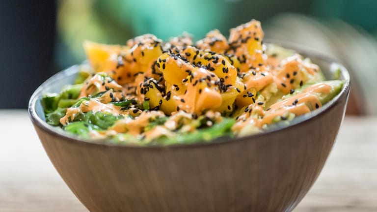 Die fertige Poke Bowl: Eine Mischung aus Lachs, Mango, Seealgen und Avocado, bestreut mit schwarzem und weißem Sesam.